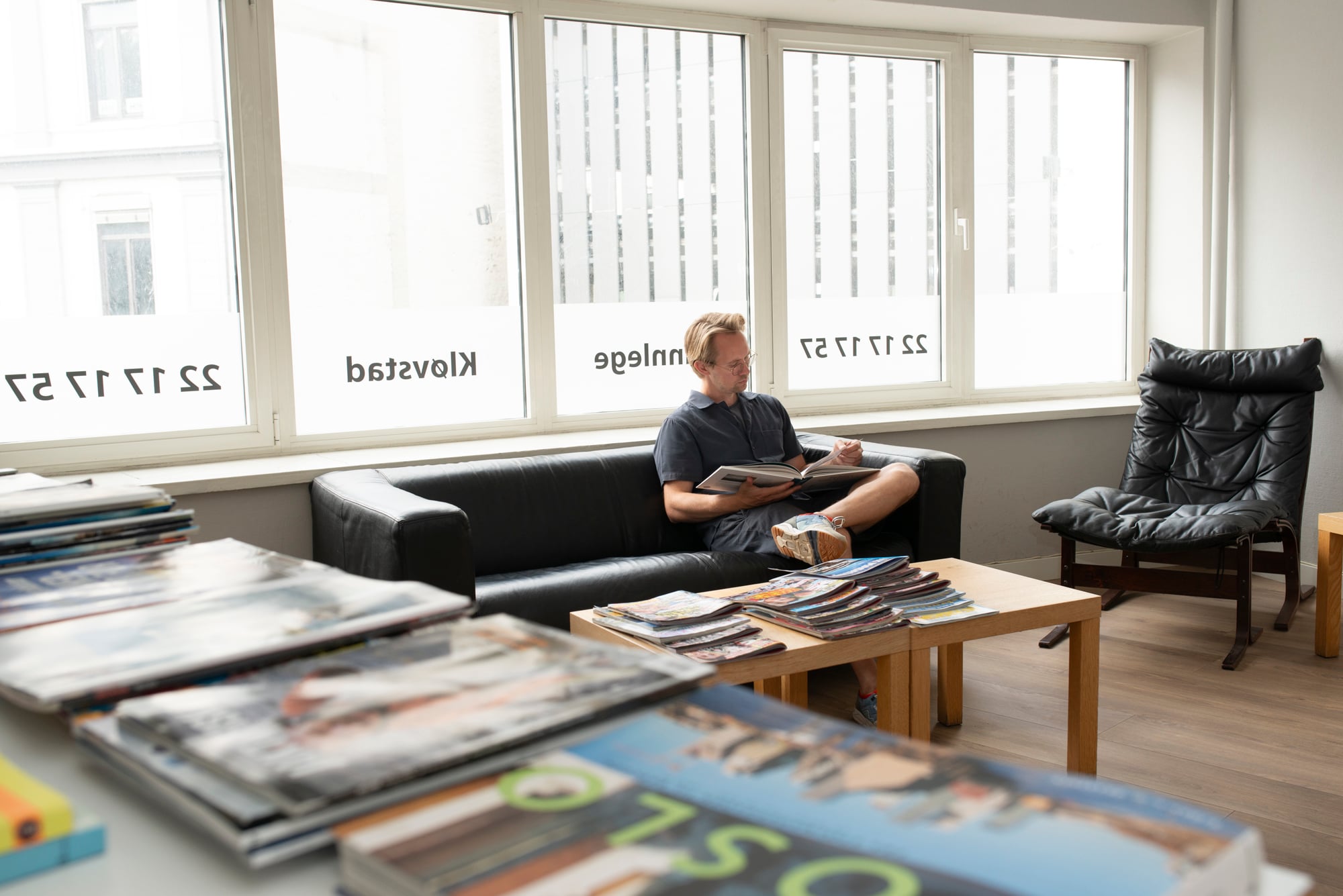 Pasient som leser i venterommet hos Tannpluss